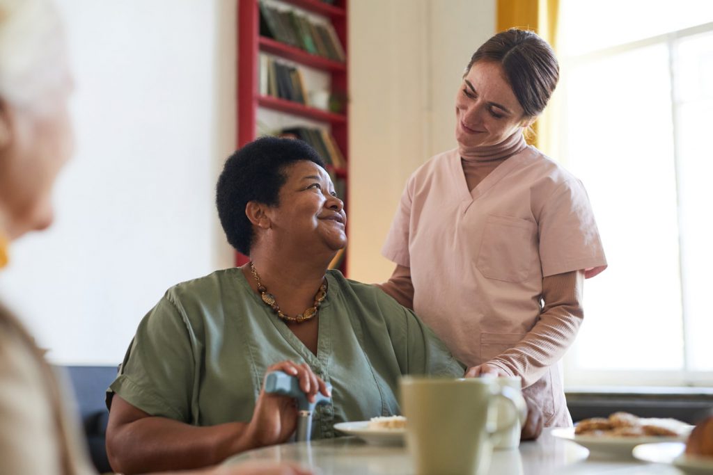 Senior carer helping a woman in her own home